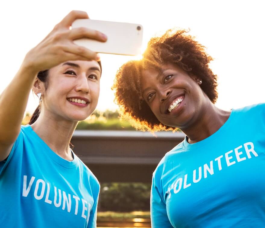 female volunteers in blue shirts taking selfie