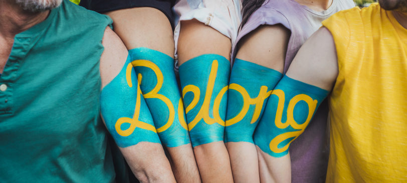 The word Belong painted on 5 people's arms
