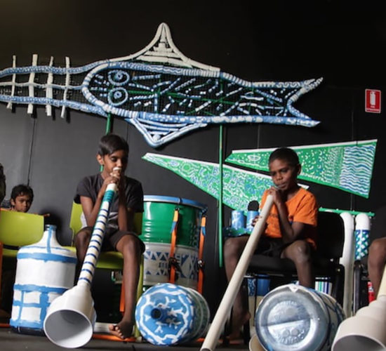 Aboriginal boys on stage playing musical instruments