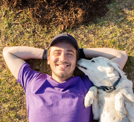 Happy man on grass with dog