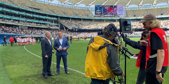Media operators filming two people on the stadium